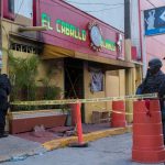 Police officers keep watch outside the “El Caballo Blanco” bar following a deadly arson attack by suspected gang members, in Coatzacoalcos