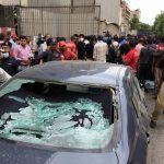 Plainclothes police officer surveys site of attack at Pakistan Stocks Exchange entrance in Karachi